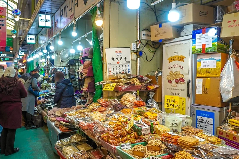 A long market aisle with diverse stalls and blurred people. - Q's Dakgangjeong: A Culinary Gem in Seoul's Bustling Mangwon Market