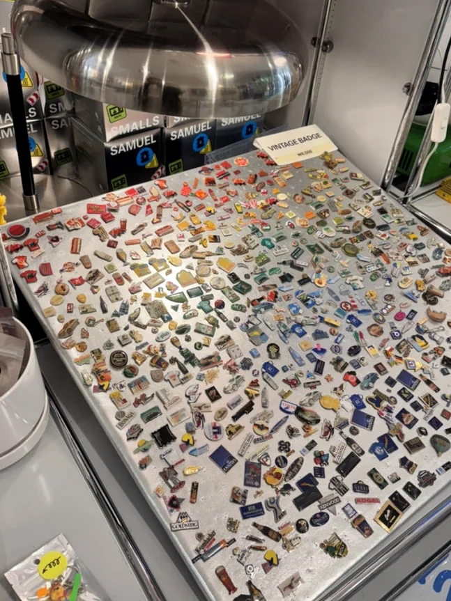 A vast collection of small colorful metal pins and badges on a table - A Masterclass in Mid-Century Curation: Navigating Samuel Smalls Seongsu Flagship