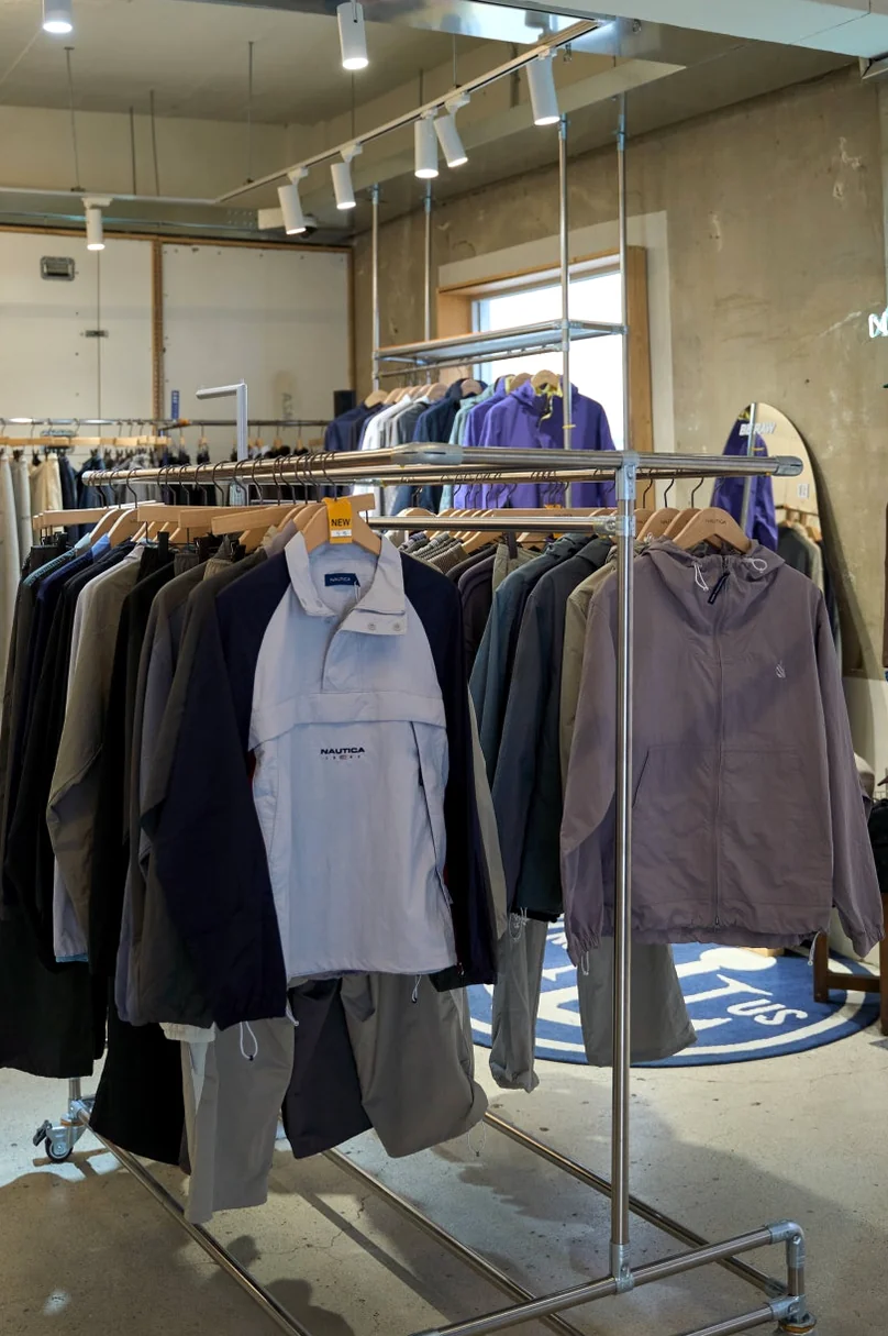 Clothing racks with various sweatshirts and hoodies in a minimalist interior space - 26SS Nautica Guide: Navigating the Hype Logistics at Worldwide Seoul Seongsu