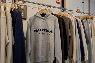 A grey Nautica hoodie with logo embroidery hanging on a metal rack - 26SS Nautica Guide: Navigating the Hype Logistics at Worldwide Seoul Seongsu