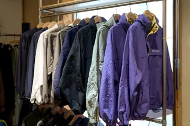 Purple and navy outdoor jackets organized on a wooden hanger rack - 26SS Nautica Guide: Navigating the Hype Logistics at Worldwide Seoul Seongsu
