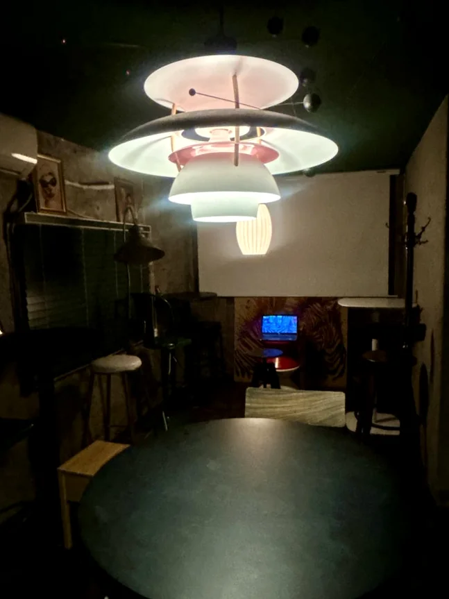 Interior with a multi-tiered modern chandelier above a dark round table. - A Cinematic Escape in Seongsu: The Deep Vibe Guide to Kumgyol Wine & LP Bar