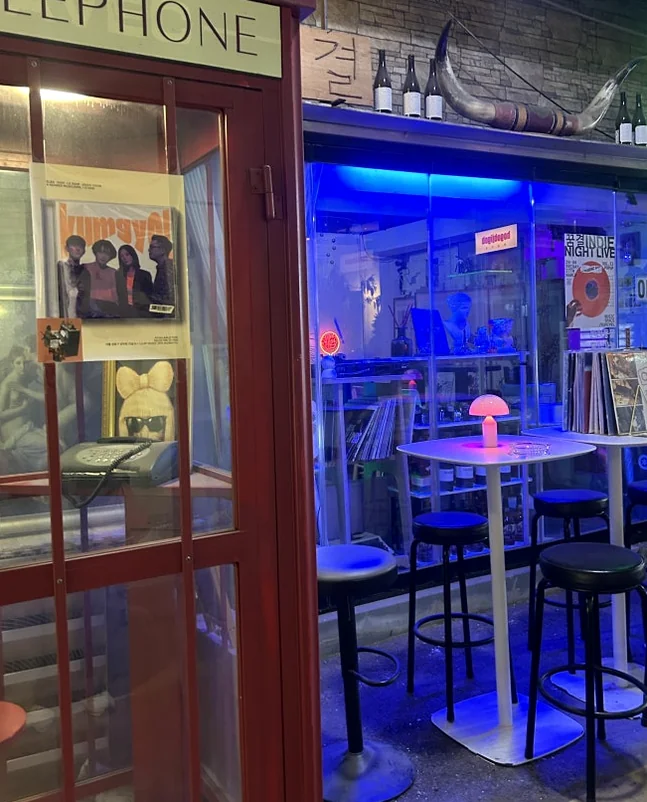 Shop exterior featuring a red telephone booth and outdoor seating with glowing pink lamps. - A Cinematic Escape in Seongsu: The Deep Vibe Guide to Kumgyol Wine & LP Bar