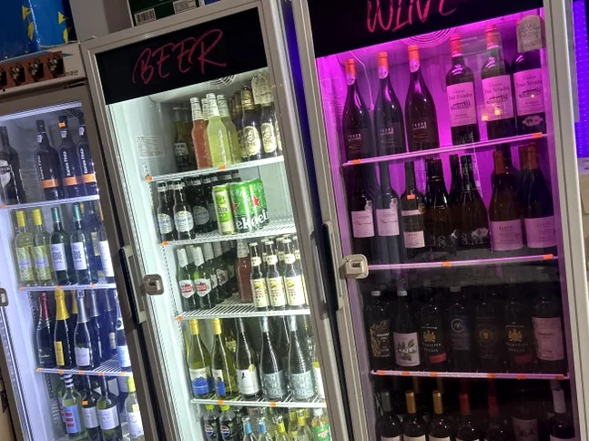 Three illuminated refrigerators displaying various beers and wines. - A Cinematic Escape in Seongsu: The Deep Vibe Guide to Kumgyol Wine & LP Bar