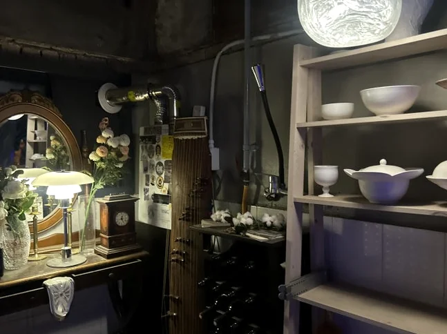 Dark interior corner with decorative shelves holding white ceramic dishes, a mirror, and a table lamp. - A Cinematic Escape in Seongsu: The Deep Vibe Guide to Kumgyol Wine & LP Bar