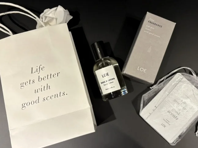 LOE 문구가 있는 쇼핑백, 향수병, 박스, 작은 파우치가 평평한 면에 놓인 모습 - Beyond Scent: A Deep Dive into LOE Seongsu Flagship Store’s Vegan Fragrance Journey