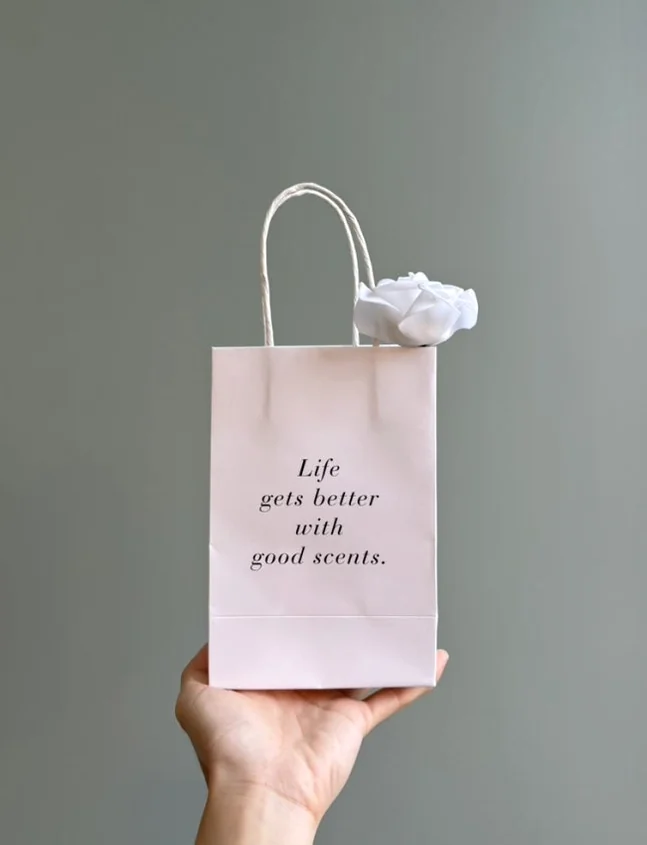 LOE EAU DE PARFUM 라벨이 있는 향수병을 들고 있는 손 - Beyond Scent: A Deep Dive into LOE Seongsu Flagship Store’s Vegan Fragrance Journey