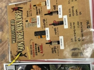 Laminated menu displaying various alcoholic beverages, including soju, beer, and wine bottles. - Exploring Hip-dang-dong's Dual Charm: From Shamanic Cocktails to Lee Young-ja's Favorite Meat Spot