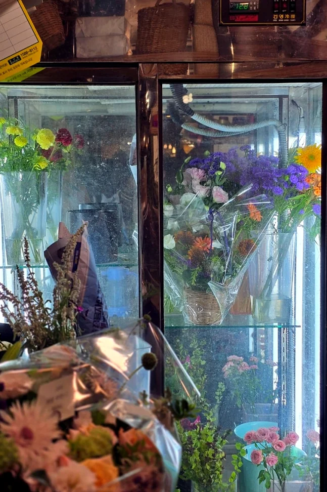 Floral arrangements and bouquets stored inside a glass-door commercial flower refrigerator - A Curator's Guide to Atelier Tium: Elevating Floral Artistry in Yeonhui-dong