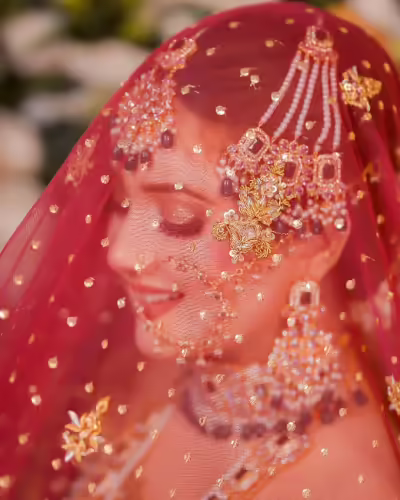 Rabeeca Khan's bridal makeup being applied, highlighting her detailed jewelry and attire.