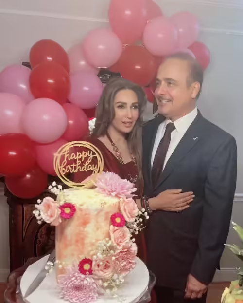 She is cutting the cake with her Husband 