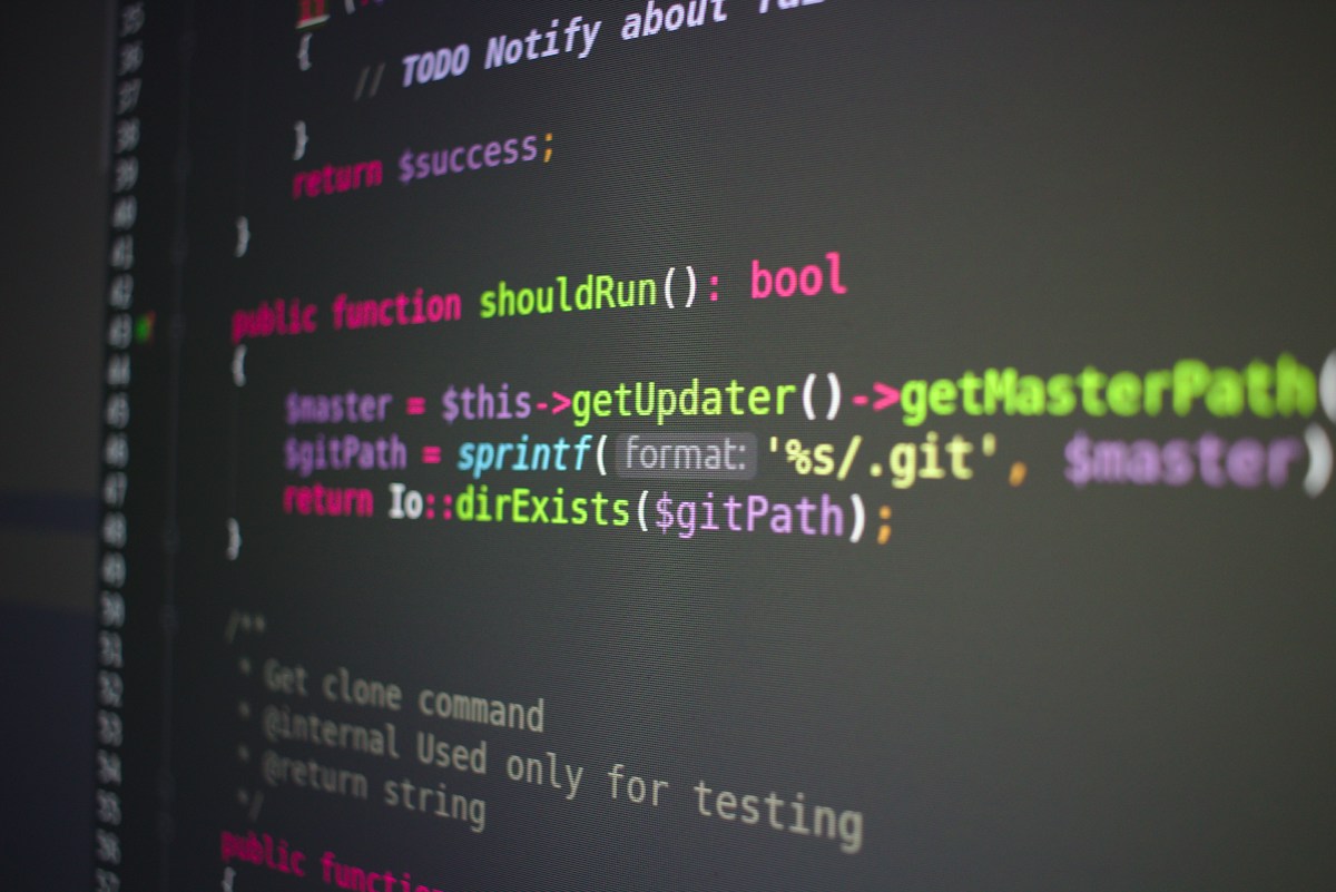 Close-up of PHP code on a dark editor screen: a shouldRun() function returning bool, using $this-> and sprintf