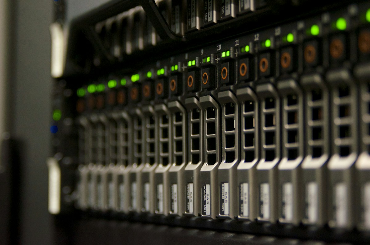 Close-up of a rack server front panel with rows of hot-swap SAS drive bays and green status LEDs
