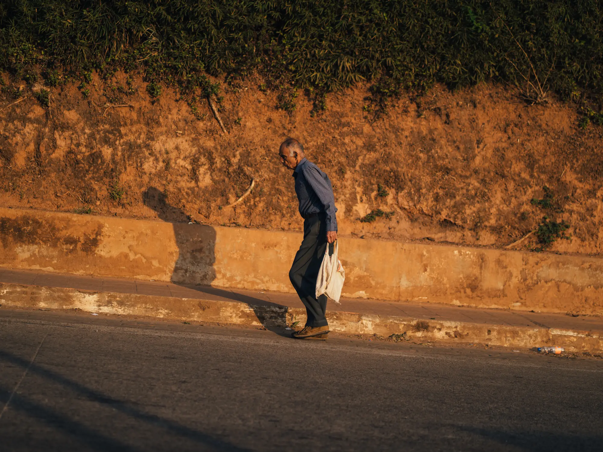An old man walking uphill, Coorg