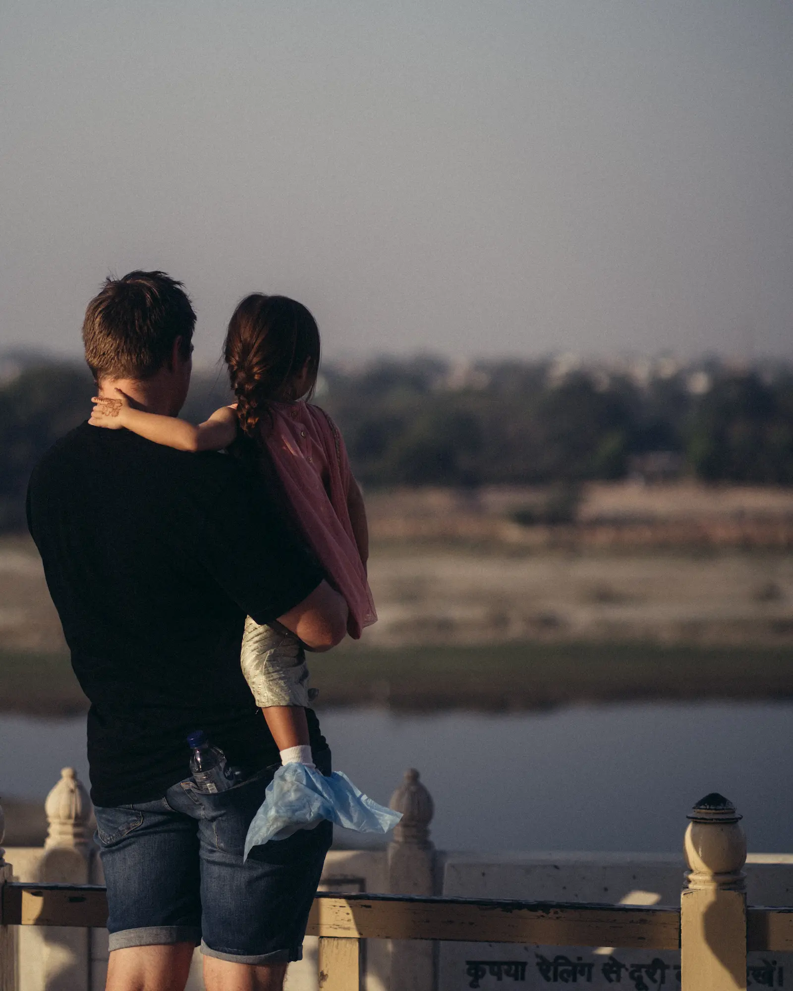 A father and daughter overlooking Yamuna river