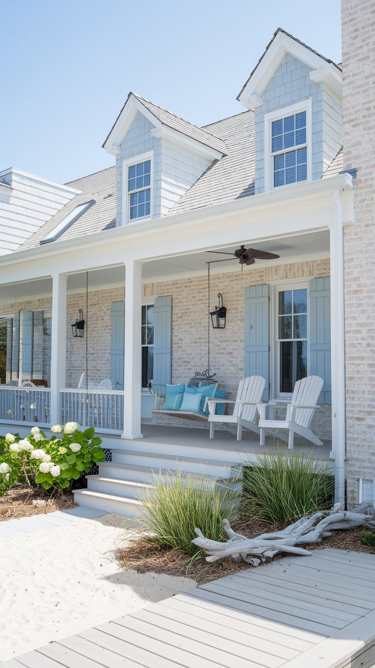 A bright, slightly elevated, daytime exterior view of a coastal style brick house with beachy hues. The brick is whitewashed in a light beige tone, creating a relaxed coastal feel.