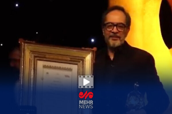 لحظه اهدای جایزه چهره سال هنر انقلاب اسلامی به کارن همایونفر