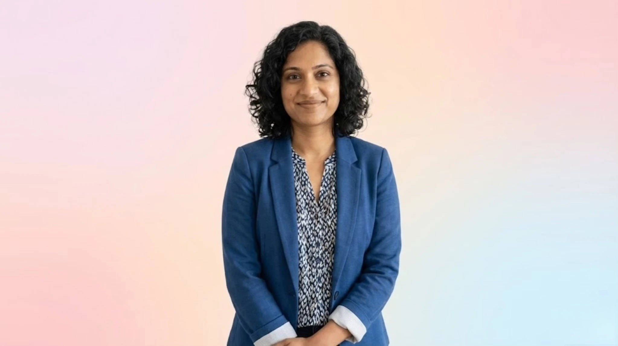 Portrait placeholder for Priya Nandakumar with warm indoor lighting