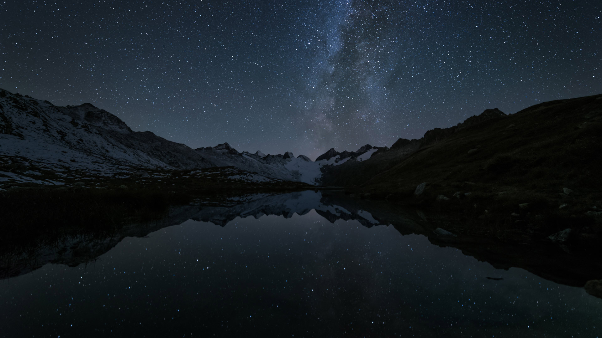 Stars reflected in the Totensee, a mountain lake at Grimsel Pass, Switzerland - magodevita/Getty Images)
