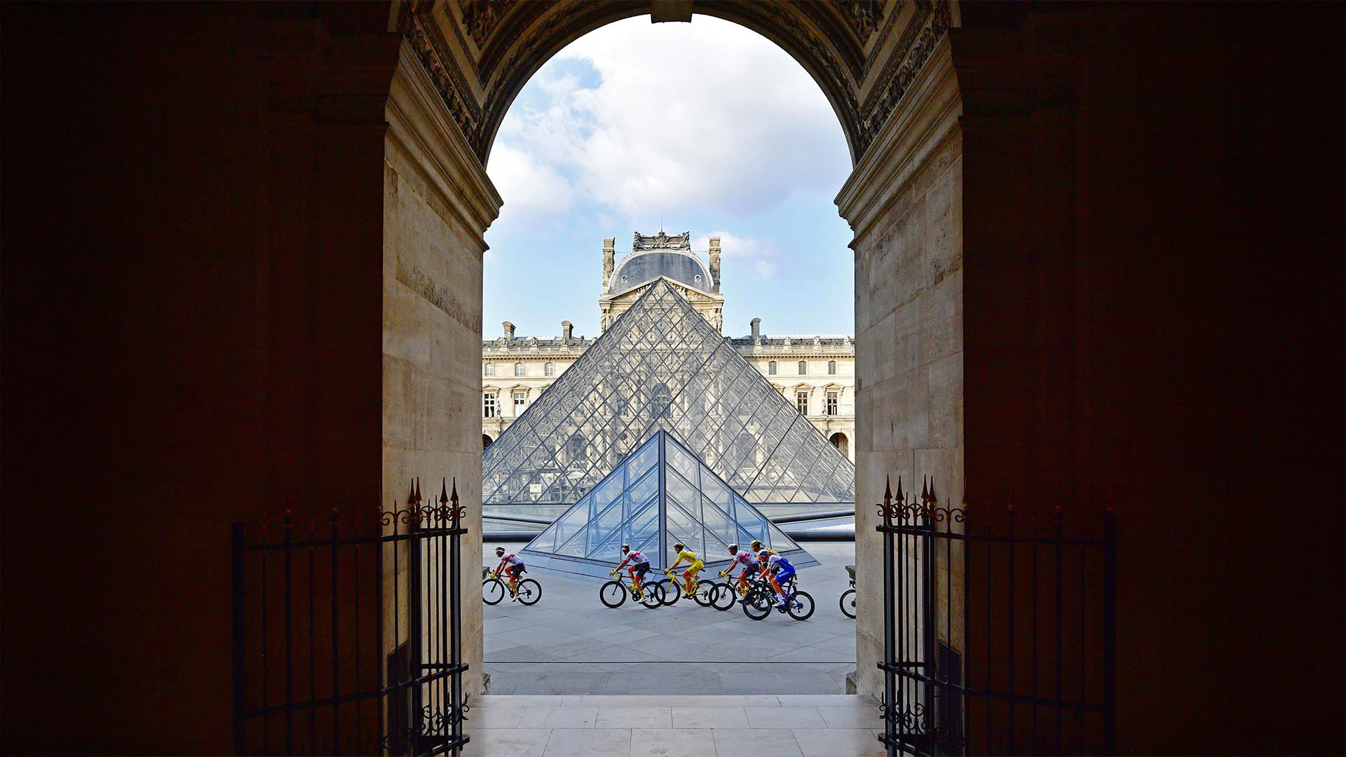 Tour de France riders in front of the Louvre Pyramid and Museum in Paris, France, during the 2020 race - Martin Bureau/AFP via Getty Images)