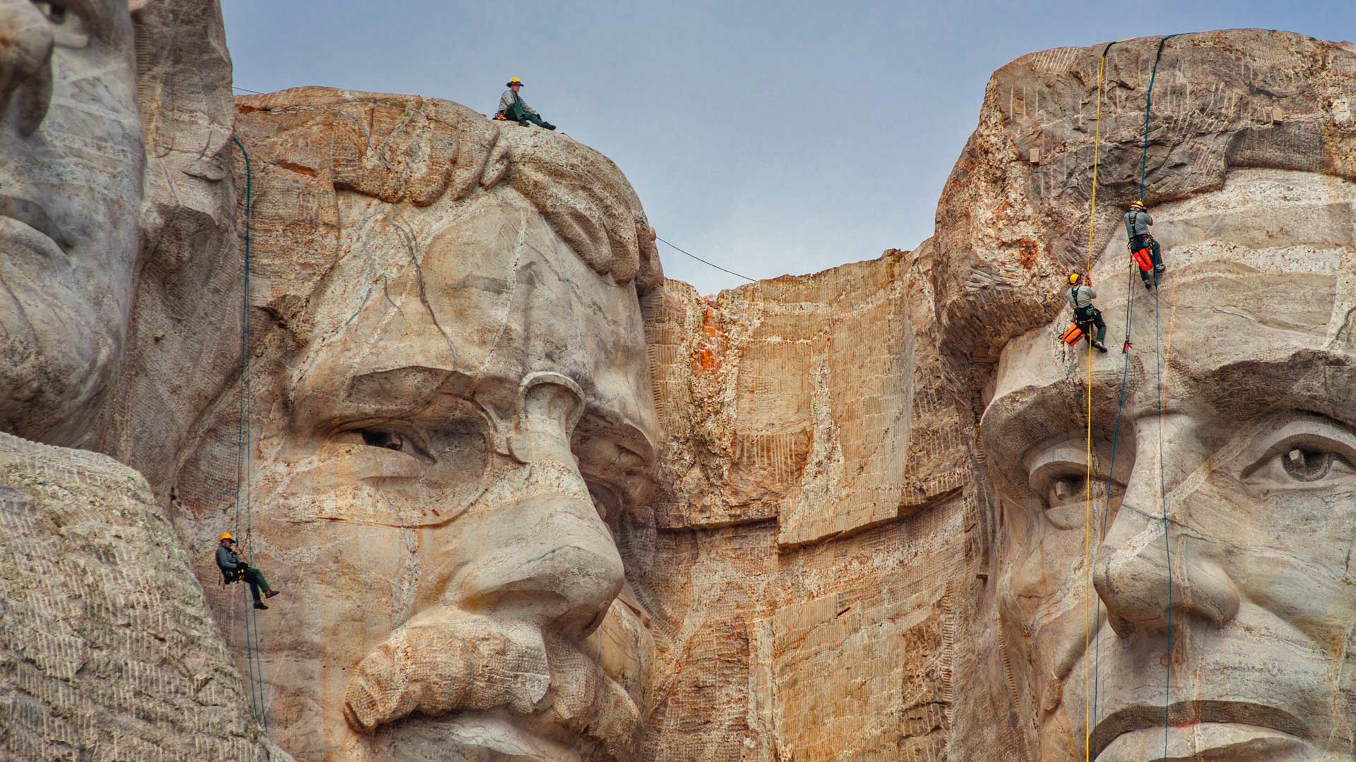 Park service employees inspecting Mount Rushmore National Memorial, South Dakota - Universal Images Group via Getty Images)