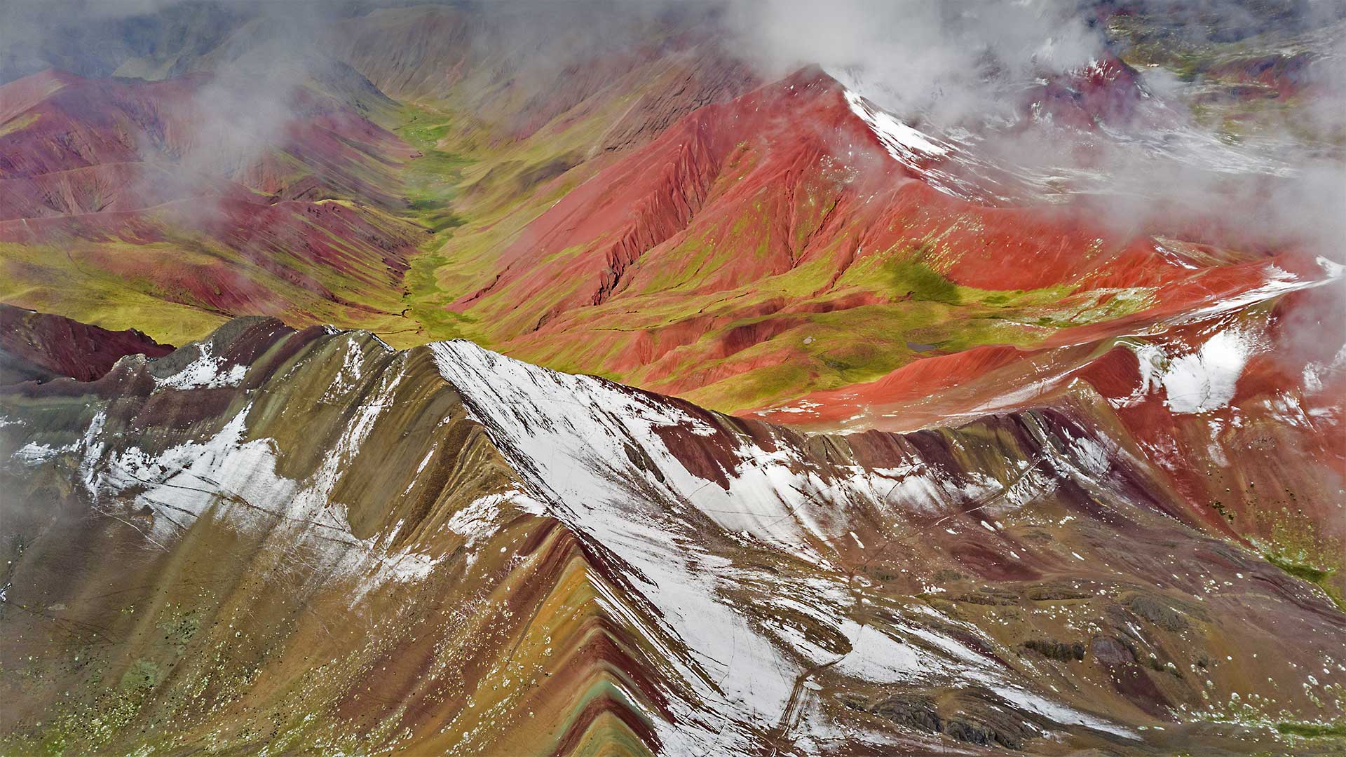 Aerial view of snowy peaks of Vinicunca (aka Rainbow Mountain), Peru - Jude Newkirk/Amazing Aerial Agency)