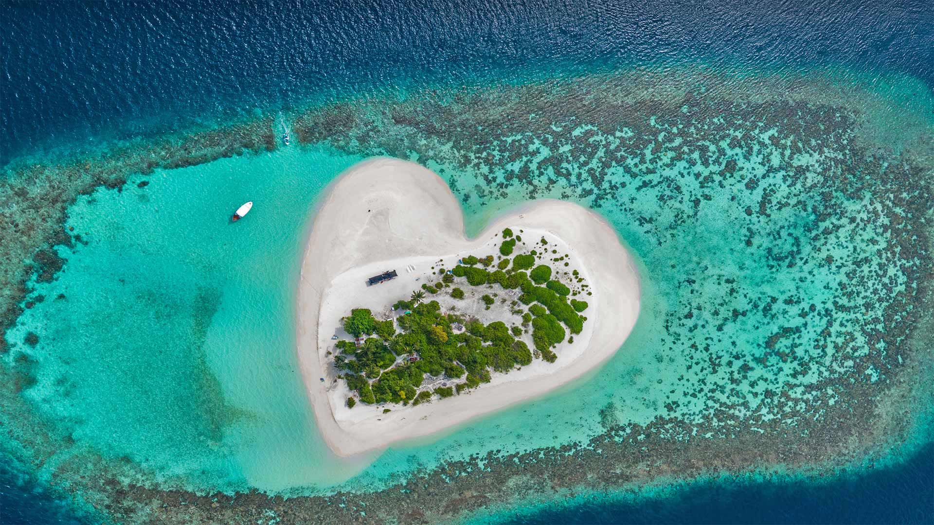 Heart-shaped island with sandy beach, offshore coral reef, Indian Ocean, Maldives - Willyam Bradberry/Shutterstock)