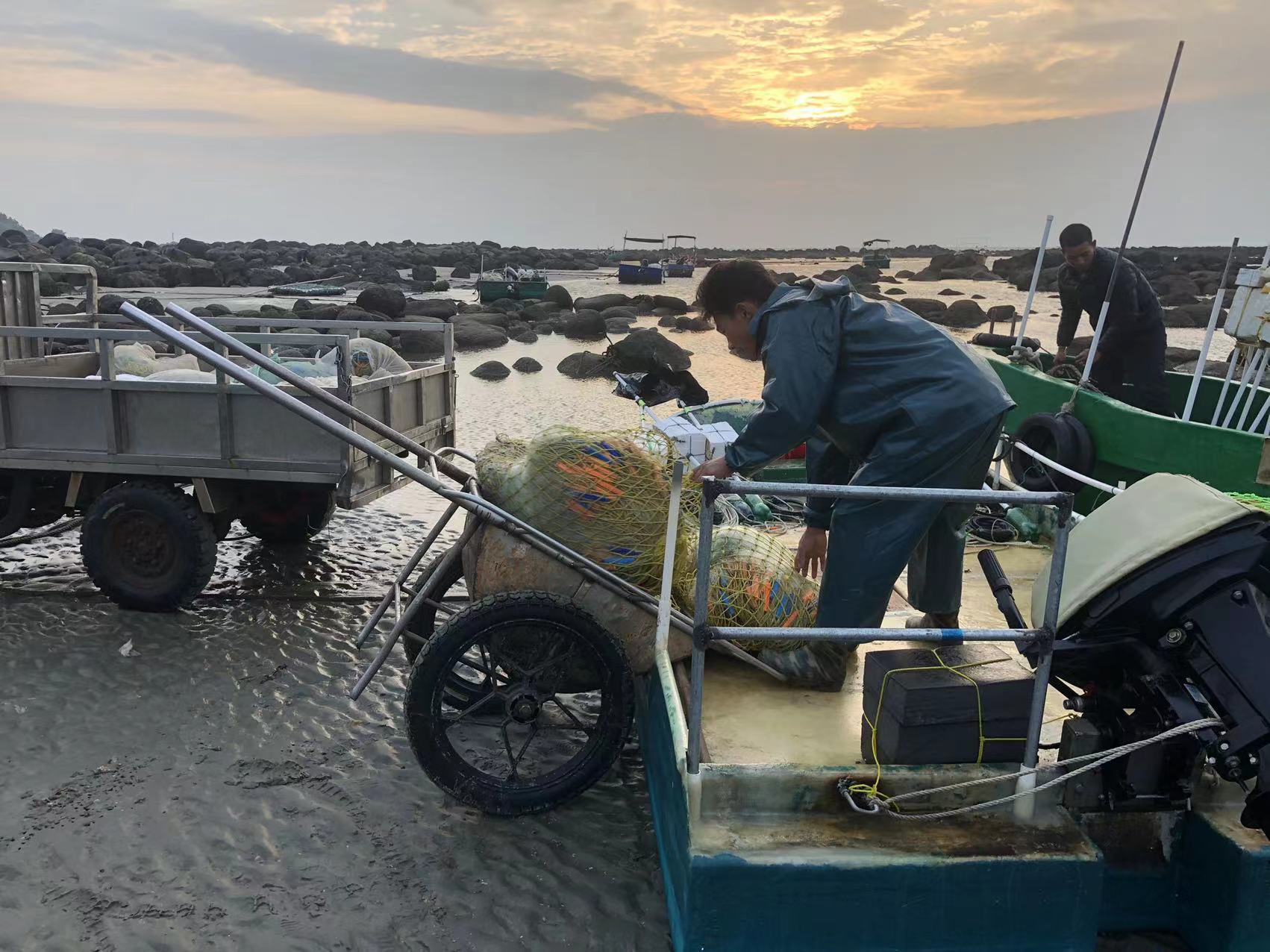 “虾皇”谢大哥将渔网搬到船上