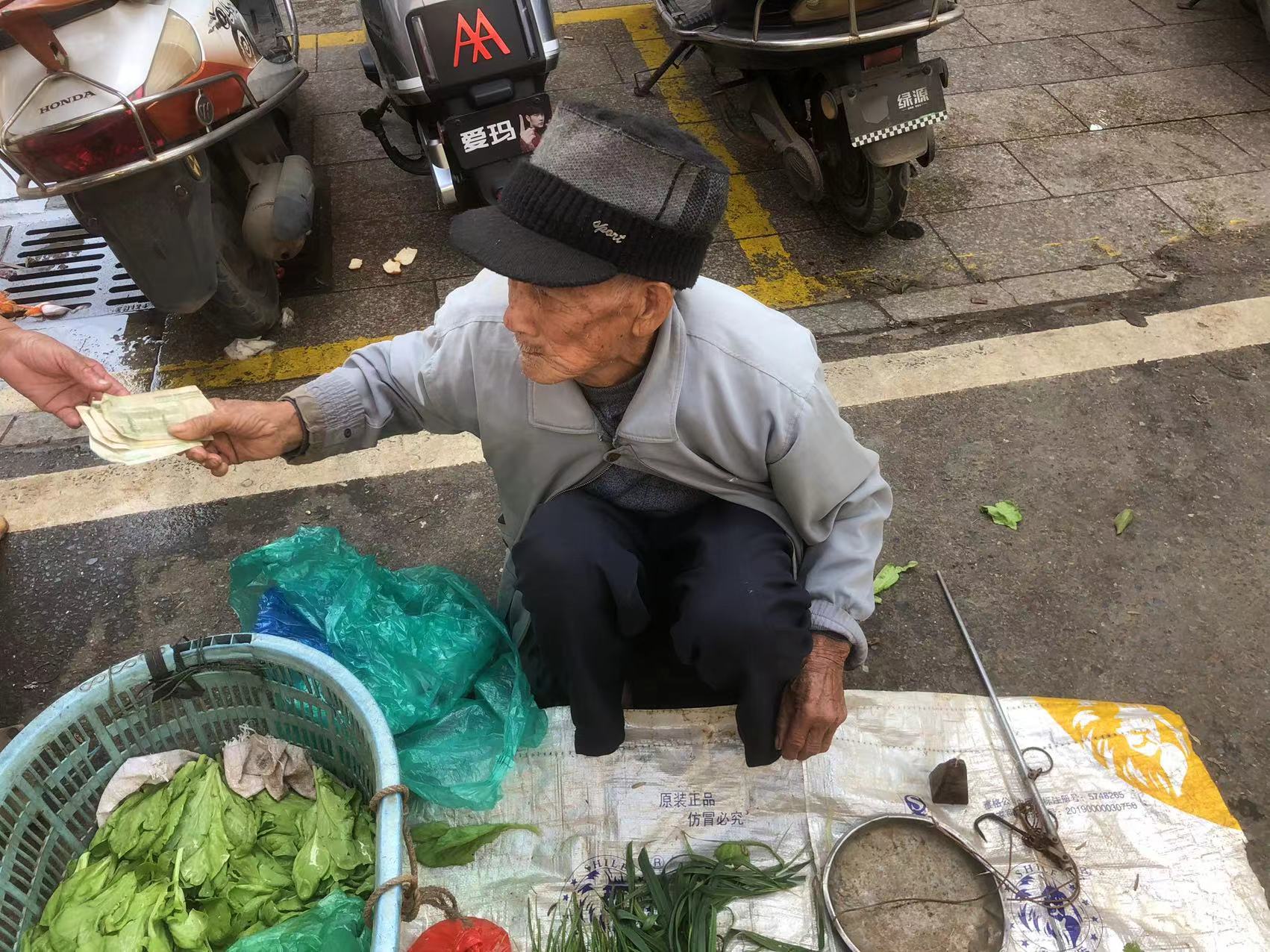 阿爷从隔壁摊主处接过现金