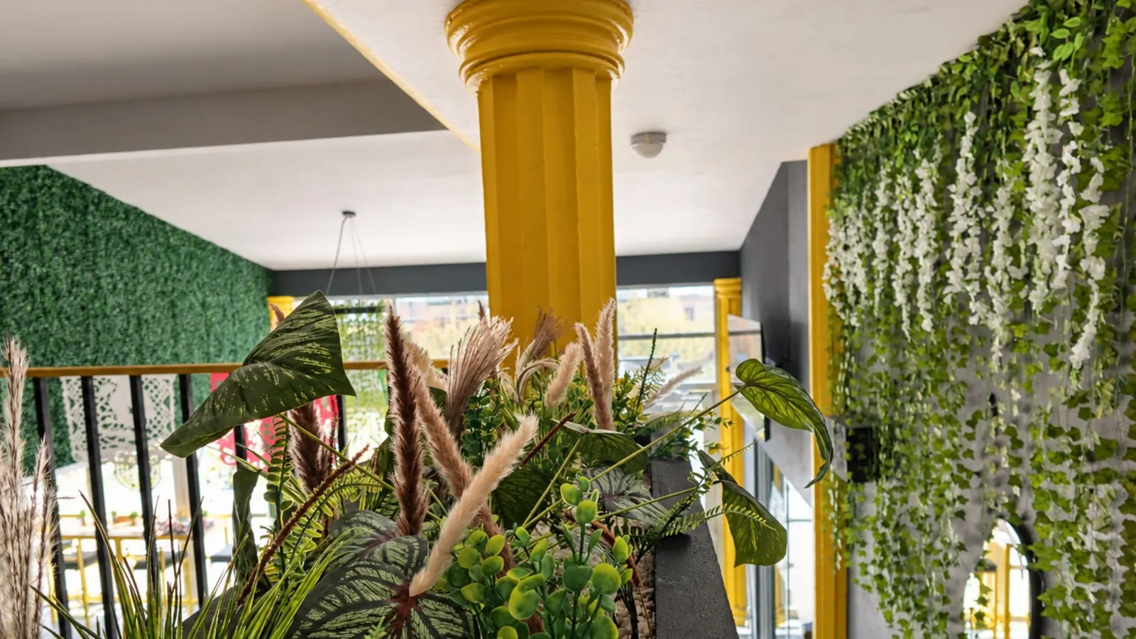 Columna amarilla y plantas del Zeus Fit Bar