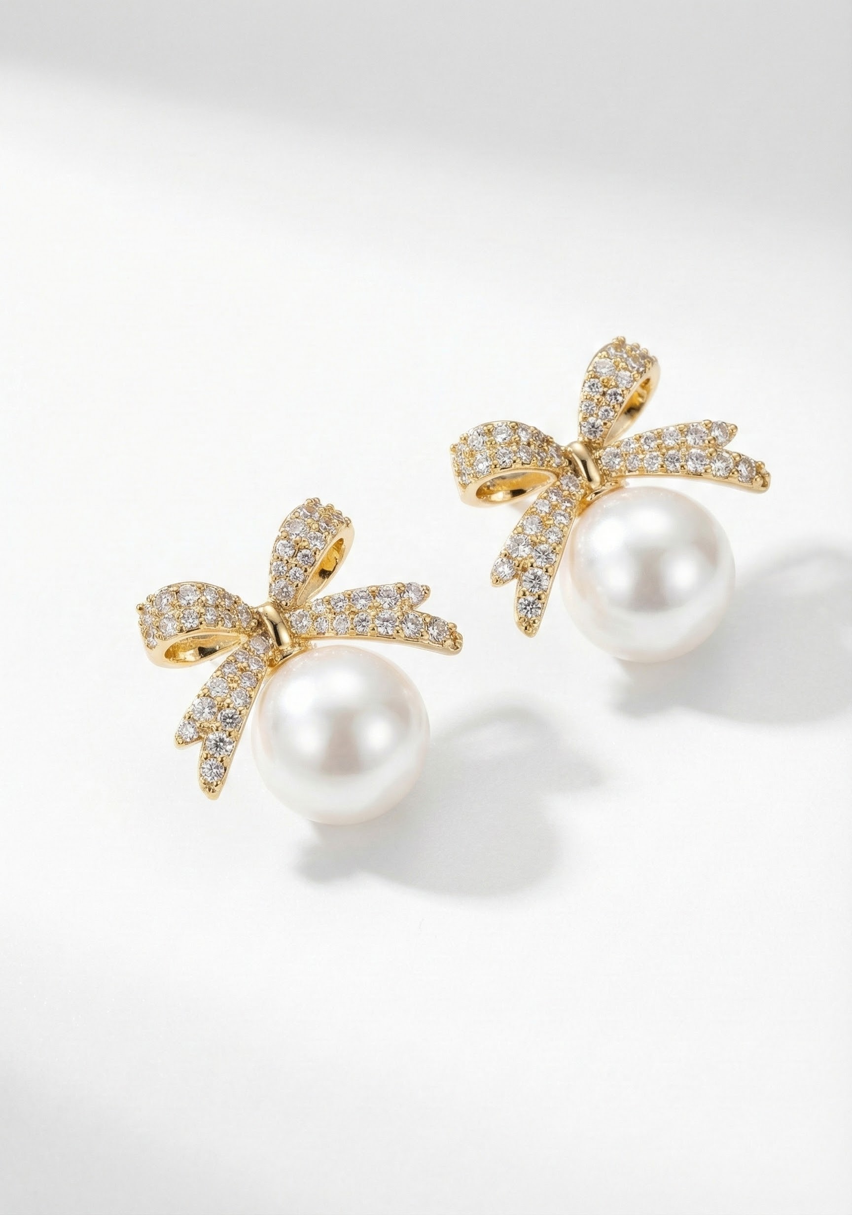 Náušnice zlatavého tónu podobě v podobě mašle s perlou