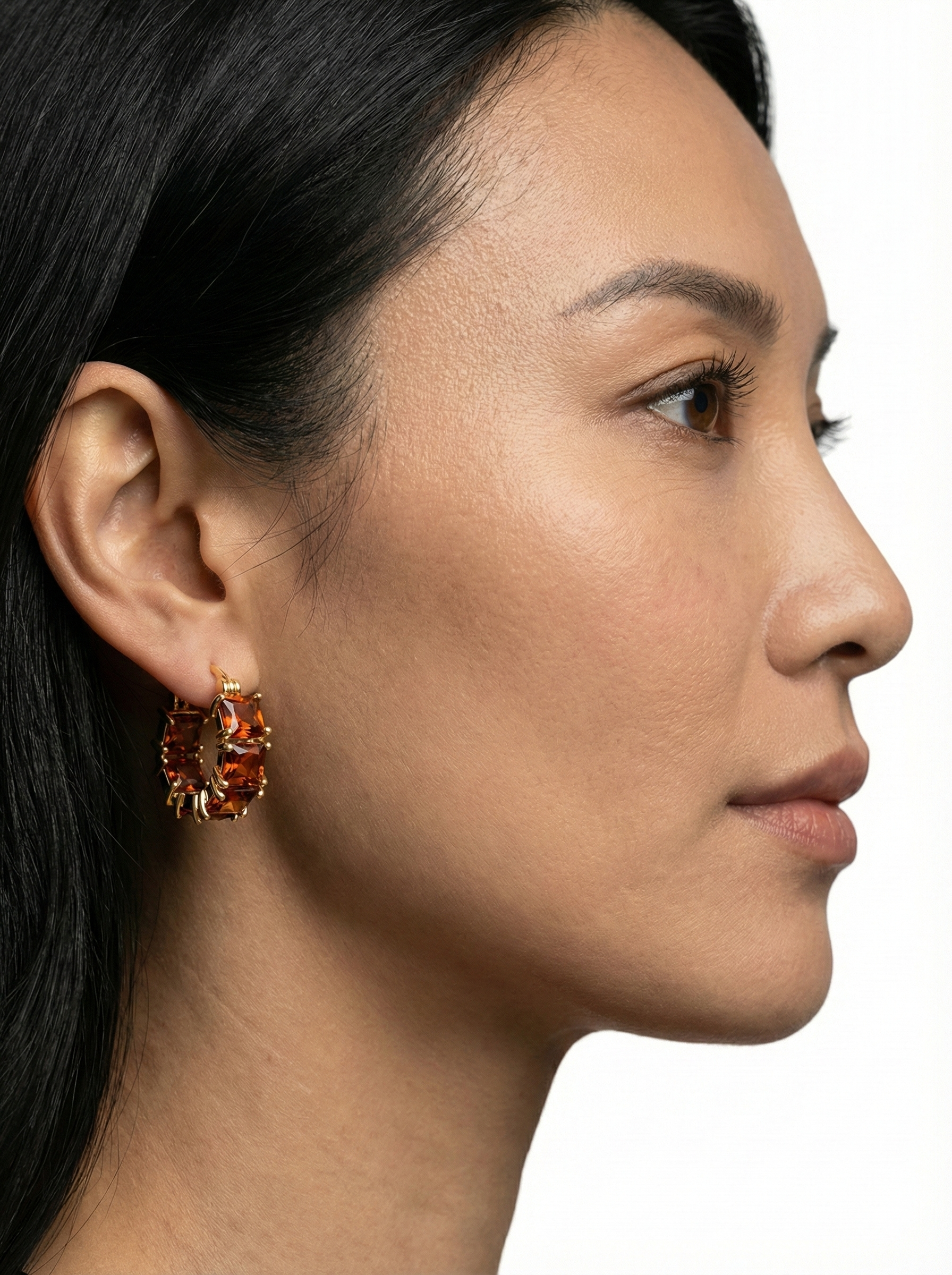 Náušnice zlatavého tónu s krystaly briliantového brusu v podobě rubínu - detail