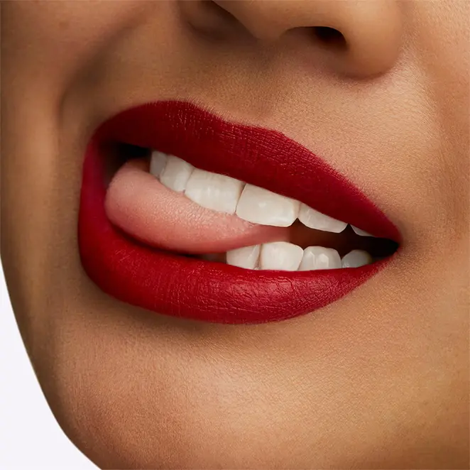 Close-up sur un sourire sublimé par le rouge à lèvres Retro Matte de MAC Cosmetics, teinte Ruby Woo