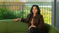 vidhya srinivasan seated on a green couch.