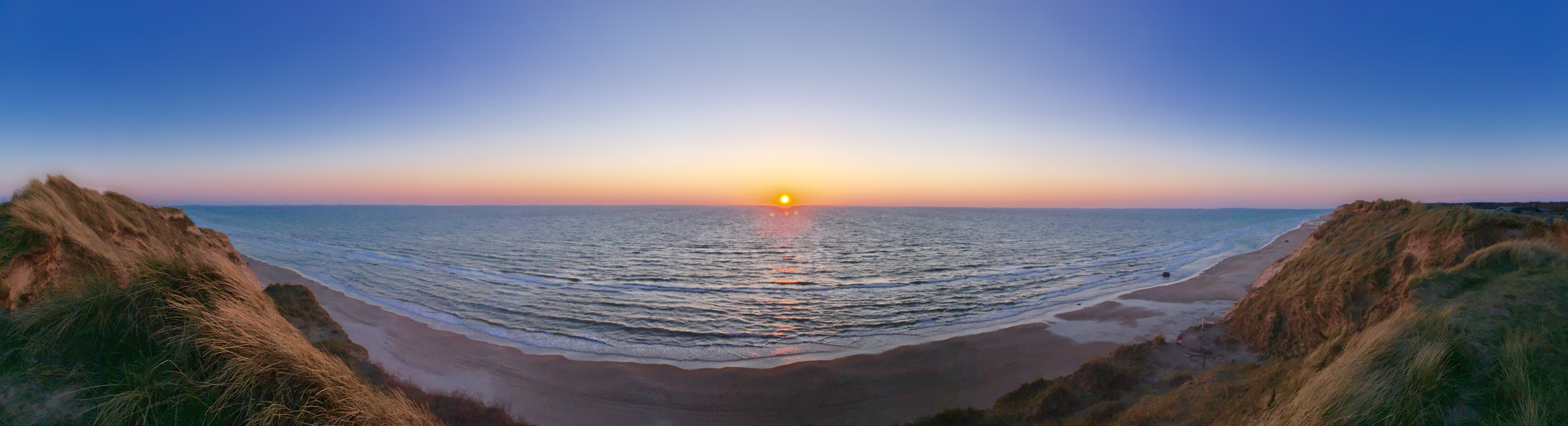 Sunset at Nørre Lyngby, Nordjylland We stood at the precipice of the sandy cliffs, in awe of the beautiful setting sun.