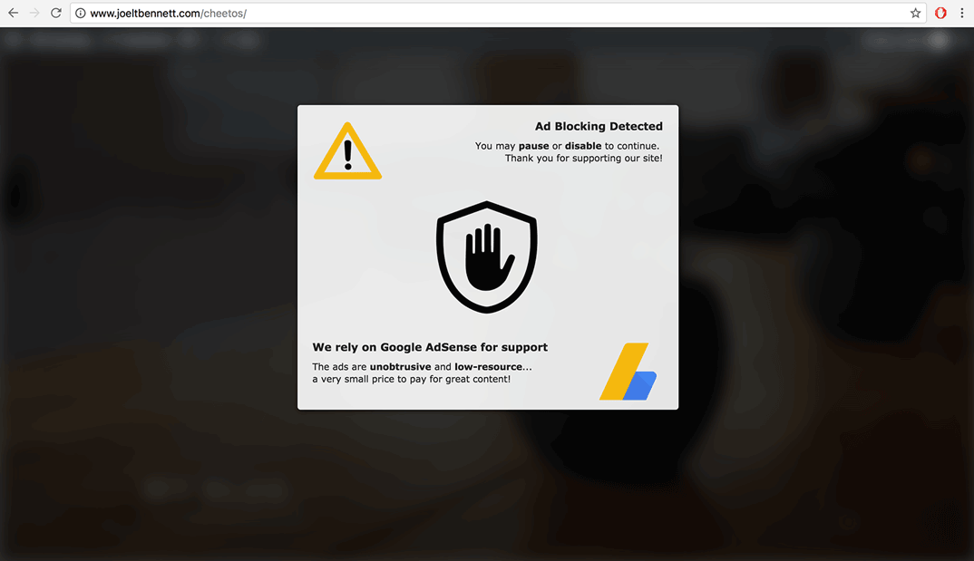 The ad wall darkens and blurs the site’s content while displaying a message.